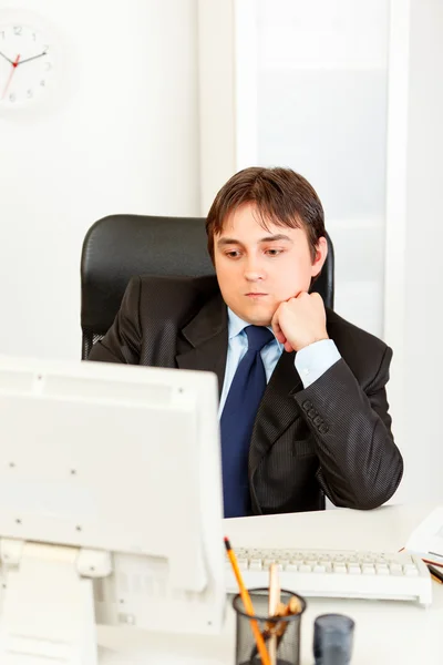 Koncentrat biznesmen z głową na ręce siedzi w biurze informacji turystycznej i looki — Zdjęcie stockowe