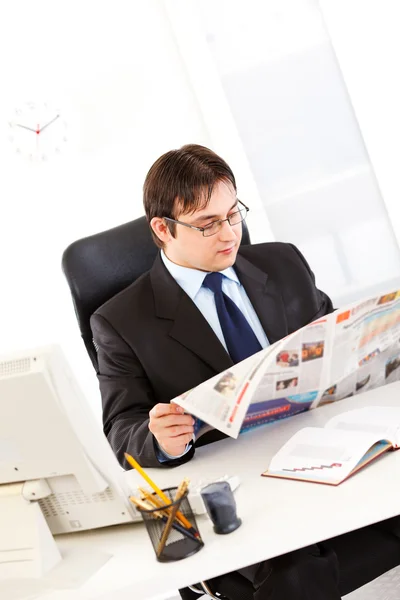 Moderna affärsman sitter vid office skrivbord och läsa tidningen — Stockfoto