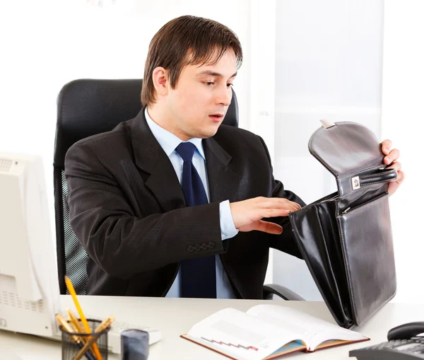Empresário chocado sentado na mesa do escritório e procurando algo em breve — Fotografia de Stock