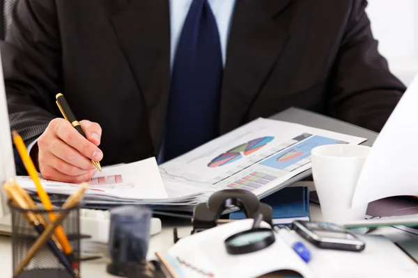 Geschäftsmann sitzt am Schreibtisch und arbeitet mit Dokumenten. Nahaufnahme. — Stockfoto