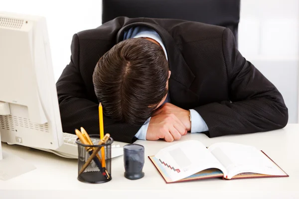 Müder Geschäftsmann schläft am Schreibtisch im Büro — Stockfoto