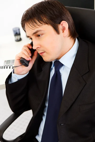Προσεκτικός νέος επιχειρηματίας που μιλάτε στο τηλέφωνο στο γραφείο — Φωτογραφία Αρχείου