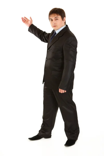 Serious young businessman pointing in corner — Stock Photo, Image