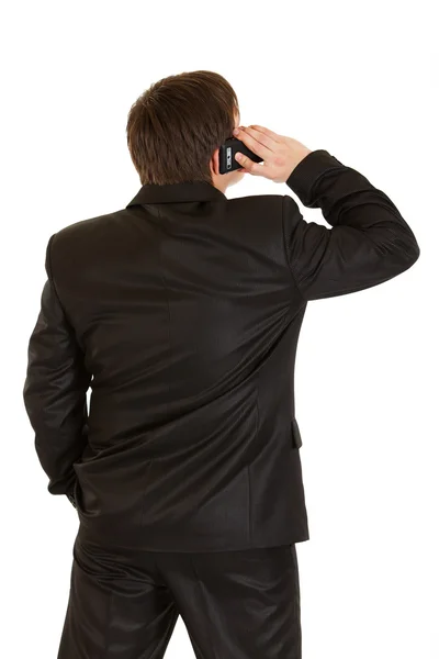 Businessman standing back to camera and talking on mobile phone — Stock Photo, Image