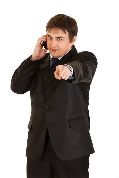 Empresário sorridente falando no celular e mostrando entre em contato comigo gesto — Fotografia de Stock