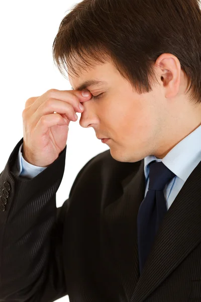 Стрессовый молодой бизнесмен держит пальцы на носу — стоковое фото