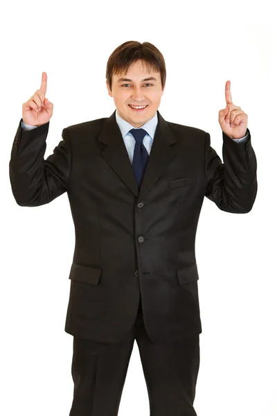 Smiling young businessman pointing up — Stock Photo, Image