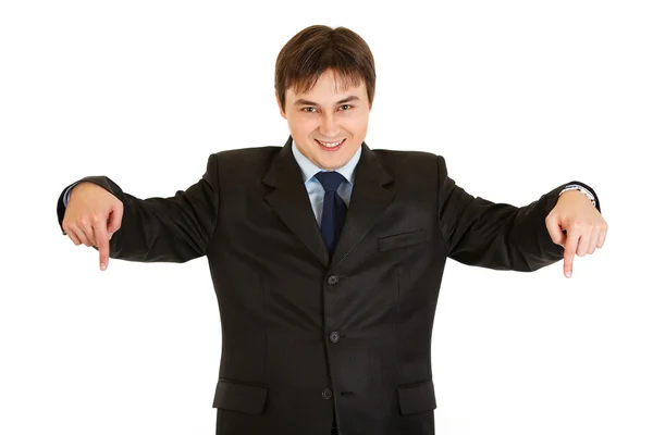 Smiling young businessman pointing down — Stock Photo, Image