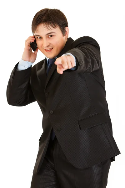 Lächelnder junger Geschäftsmann, der mit dem Handy telefoniert und mit dem Finger auf Jo zeigt — Stockfoto