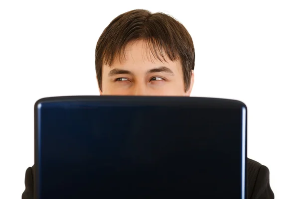 Uomo d'affari moderno cautamente guardando fuori dal computer portatile — Foto Stock