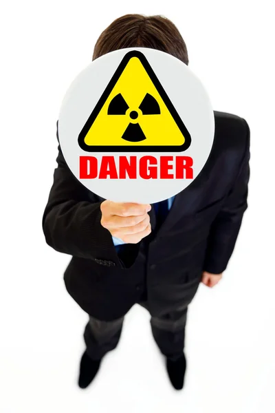 Danger d'irradiation ! Homme d'affaires tenant un panneau de rayonnement devant f — Photo