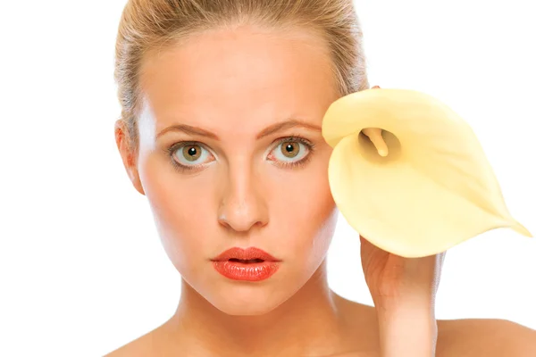 美しい若い女性の顔に近い黄色のオランダカイウユリ — ストック写真