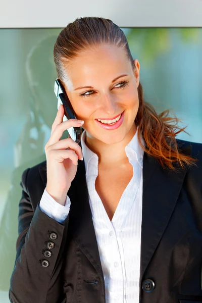 事務所ビルでの携帯電話で話しているビジネスの女性の笑顔の肖像画 — ストック写真
