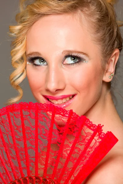 Portret van lachende mooi meisje met textiel ventilator — Stockfoto