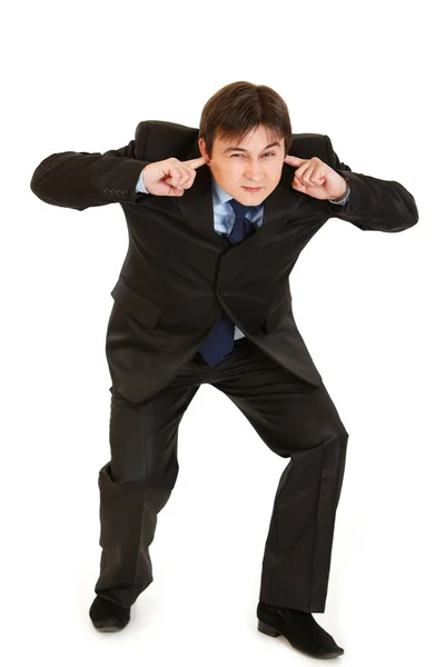 Young businessman ducking in fear and closing ears with fingers Stock Image