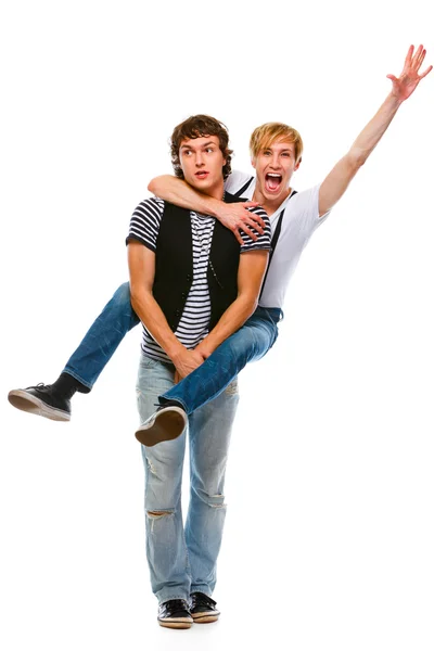 stock image Cheerful teenager piggy backing his friend. Isolated on white
