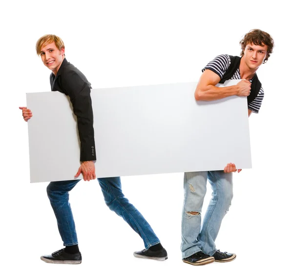 Dos adolescentes tirando de cartelera en blanco. Aislado sobre blanco —  Fotos de Stock