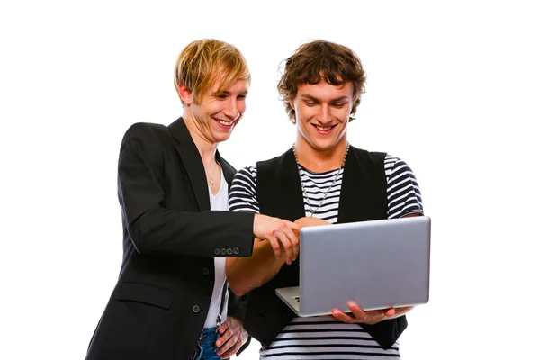 Δύο χαμογελώντας νέοι που ψάχνουν σε φορητό υπολογιστή. απομονωθεί σε λευκό — Φωτογραφία Αρχείου