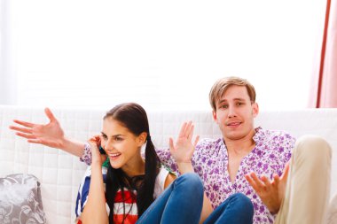 Young man dissatisfied with long time talking on phone girlfrien clipart