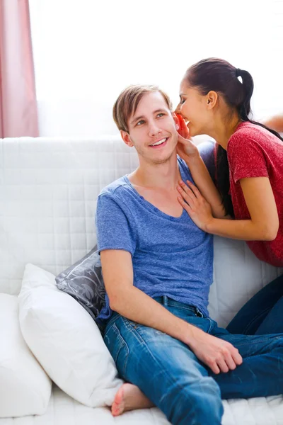 Girl whispering something in boyfriends ear — Stock Photo, Image