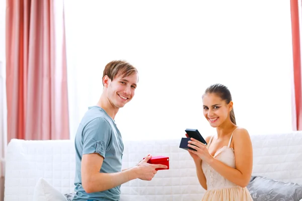Glückliches junges Paar tauscht Geschenke aus — Stockfoto