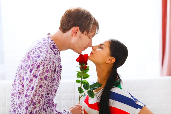 Junger Mann überreicht ihrer Freundin rote Rose — Stockfoto