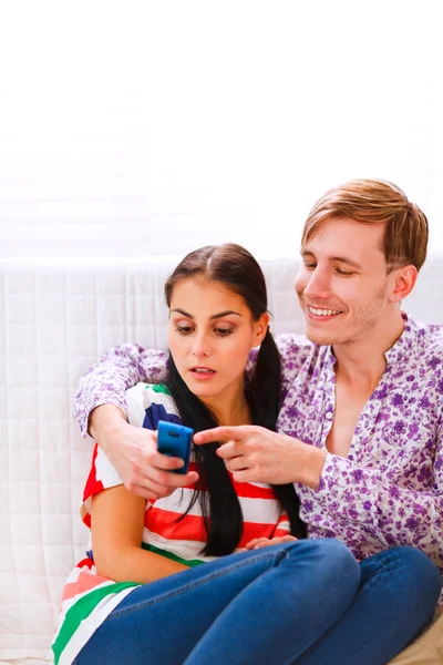 Jovem mostrando algo no celular para sua namorada surpreso — Fotografia de Stock
