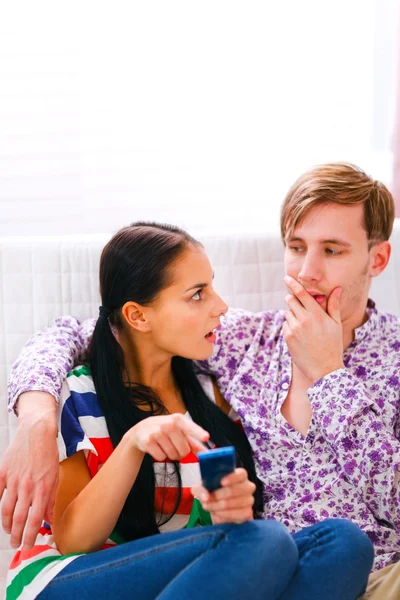 Angry girl pointing on mobile and looking on confused boyfriend — Stock Photo, Image