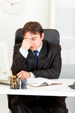 ofis masa başında oturan yorgun modern iş adamı