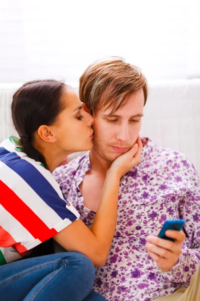 Girl trying to distract her busy boyfriend from mobile phone — Stock Photo, Image