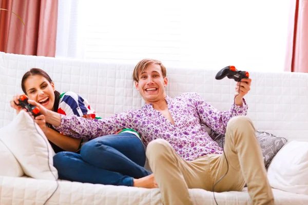 Młody człowiek biorąc joysticka z dziewczyną wygranej podczas gry — Zdjęcie stockowe