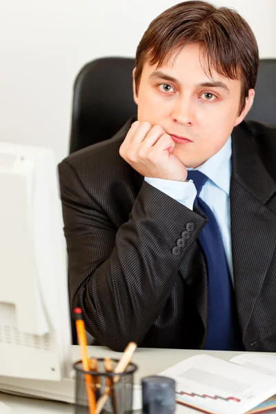 Thoughtful modern businessman sitting at office desk — Stock Photo, Image
