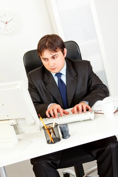 Στοχαστικό επιχειρηματία που κάθεται στο γραφείο και να εργάζονται στον υπολογιστή — Φωτογραφία Αρχείου