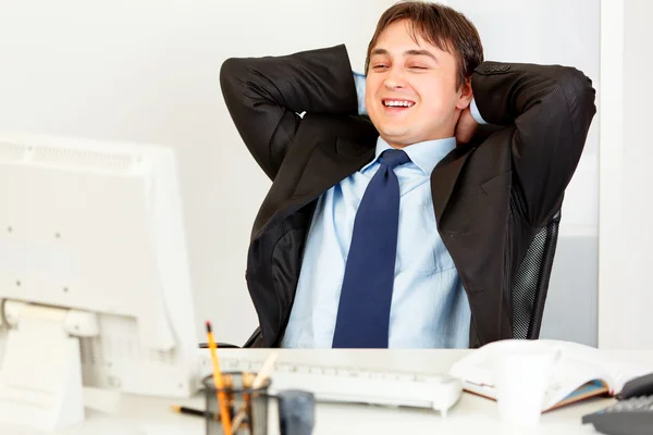 Skrattar affärsman sitter på kontoret skrivbordet och titta på datorer överva — Stockfoto