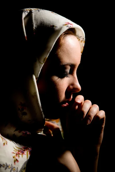 stock image Portrait of pretty praying girl with old russian shawl on head.