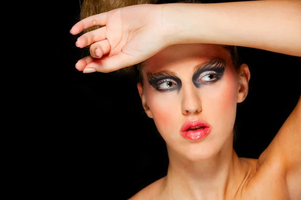 Mooie vrouw met extravagante make-up en hand op hoofd — Stockfoto