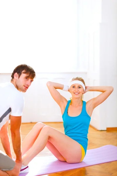 Smiling fit girl making abdominal crunch — Stock Photo, Image