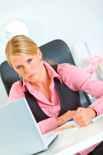Mujer de negocios enojado sentado en el escritorio de oficina y de la mano junto a la cabeza — Stok fotoğraf