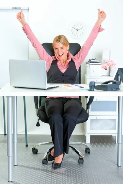Donna d'affari eccitata seduta alla scrivania dell'ufficio e che si rallegra del suo successo — Foto Stock