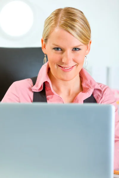 Счастливая деловая женщина работает на ноутбуке в офисе — стоковое фото