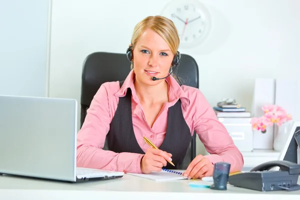 Femme manager moderne souriante avec casque sur le lieu de travail — Photo