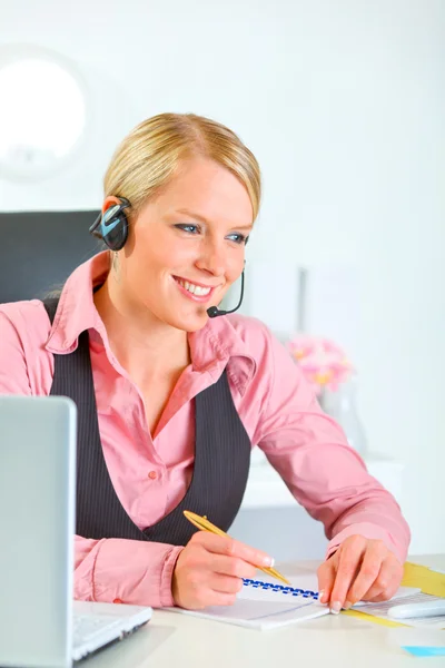 Femme manager moderne souriante avec casque de travail au bureau — Photo
