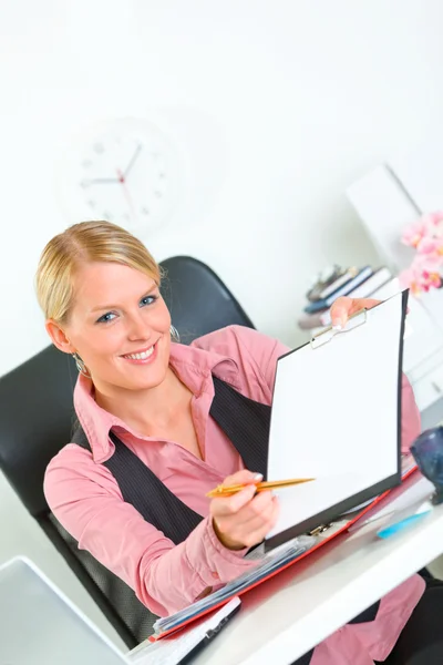 Smiling business woman sitting at office desk with document — Stock Photo, Image