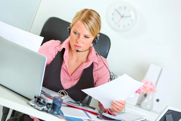Förvirrad kvinnlig manager med headsetet på arbetar plats — Stockfoto