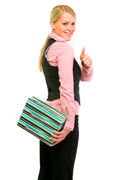 Smiling business woman hiding gift and showing thumbs up — Stockfoto
