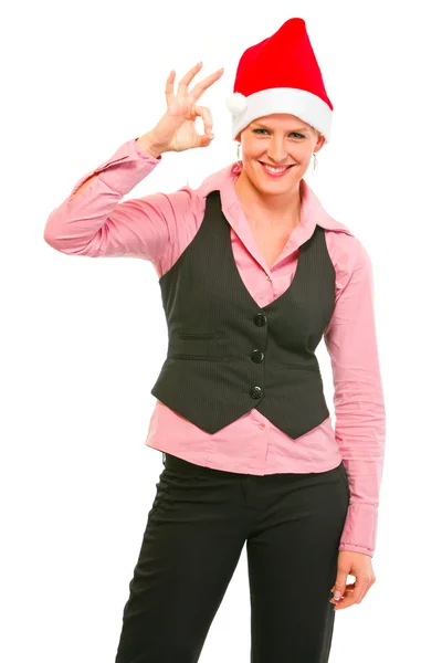 Χαρούμενα θηλυκό διευθυντής στην το καπέλο santa δείχνει εντάξει χειρονομία — Φωτογραφία Αρχείου