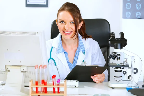 Usmívající se žena lékaře pracující v kanceláři — Stock fotografie