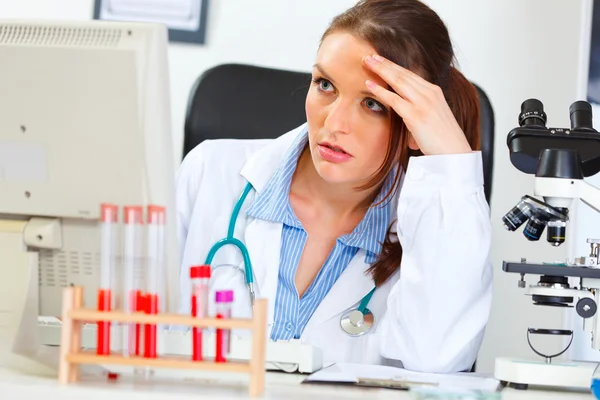 Skoncentrowany kobieta lekarz siedzi w biurze i pracy na compu — Zdjęcie stockowe