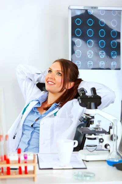Ärztin sitzt am Bürotisch und entspannt — Stockfoto