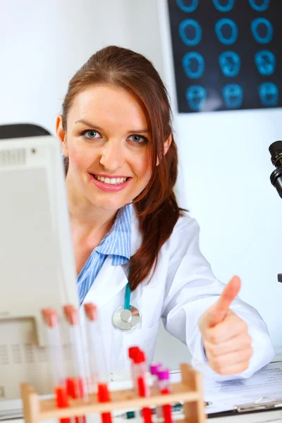Médico femenino trabajando en la computadora y mostrando los pulgares hacia arriba —  Fotos de Stock